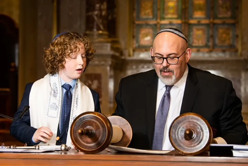 young man saying prayers with rabbi