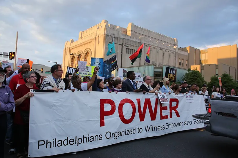 People holding a large banner for a parade