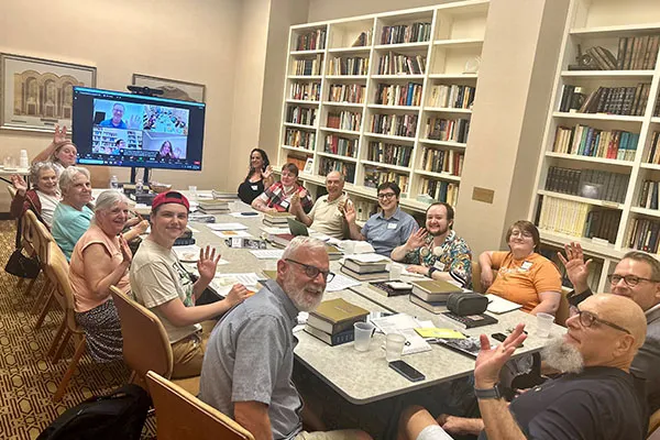 group of people sitting at tables in a class