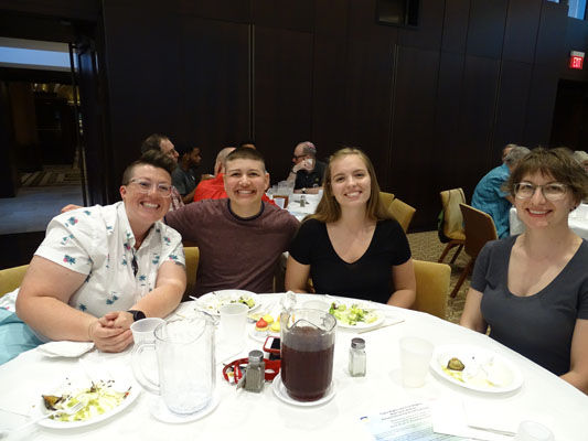 men and women at tables for Pride Shabbat