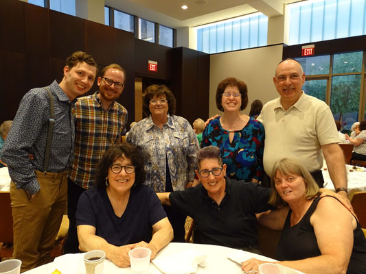 men and women at tables for Pride Shabbat