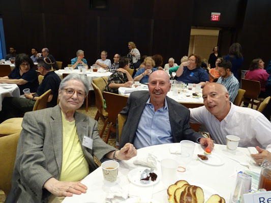 men and women at tables for Pride Shabbat