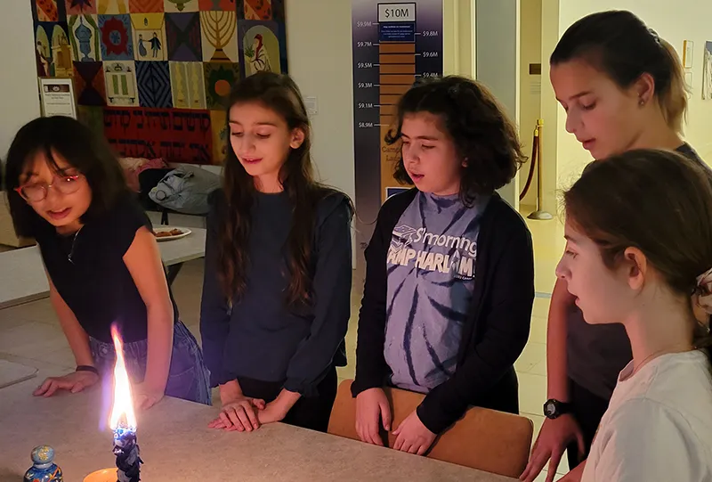 kids saying prayers over a candle