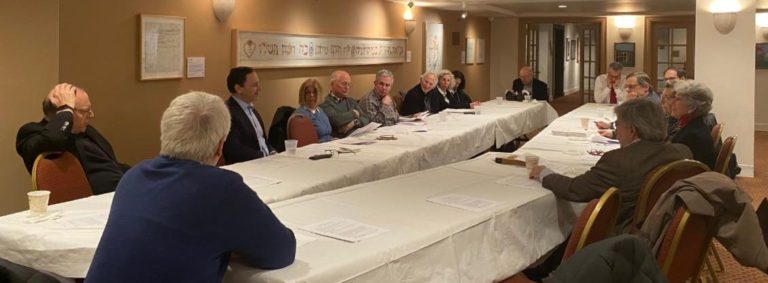 Lawyers group seated at long tables during a meeting