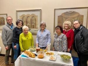 group of people at a table filled with food