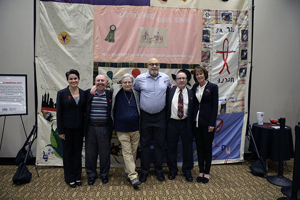 Congregants standing infant of a section of the AIDS quilt