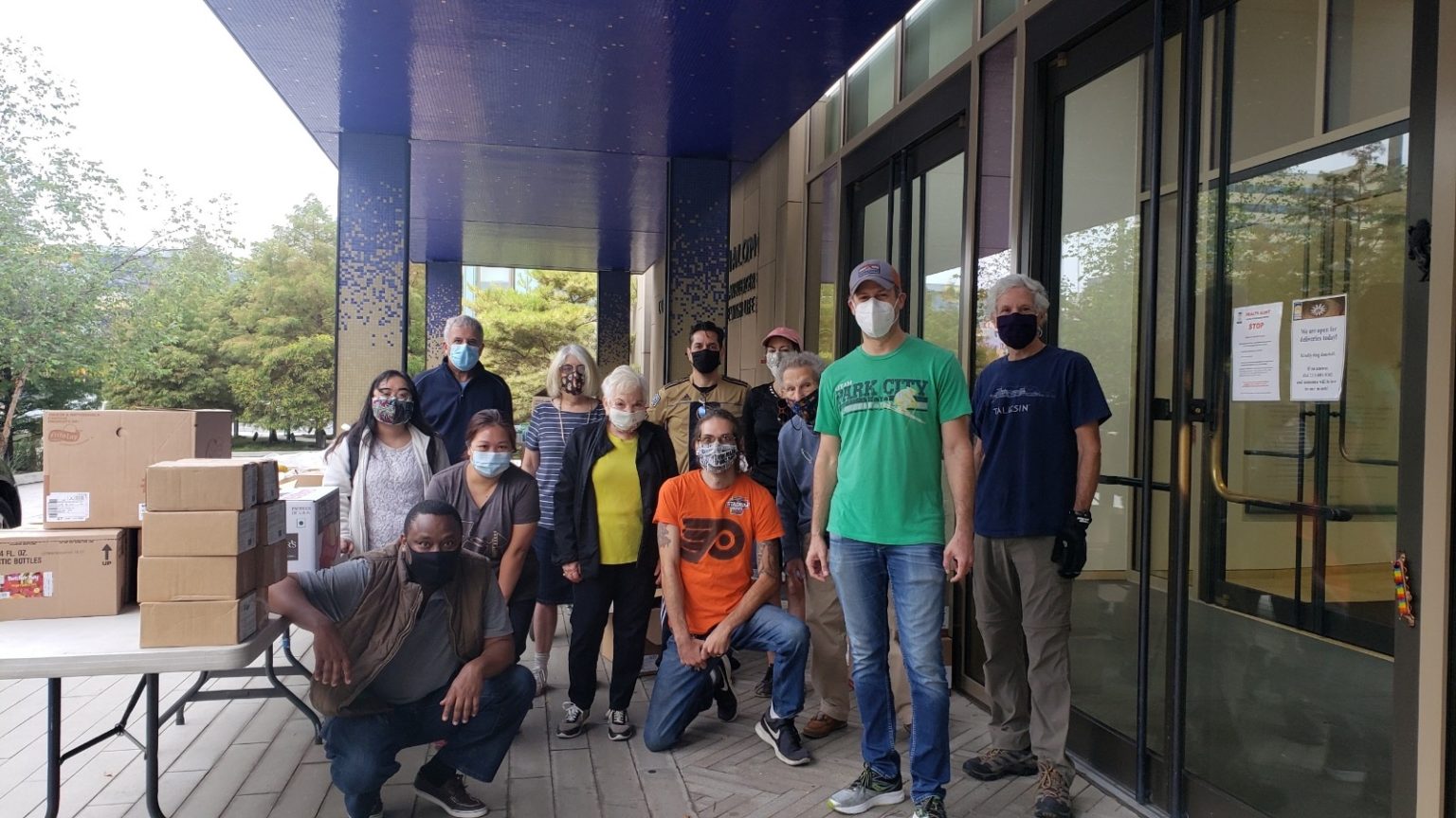 group of people wearing masks collecting food